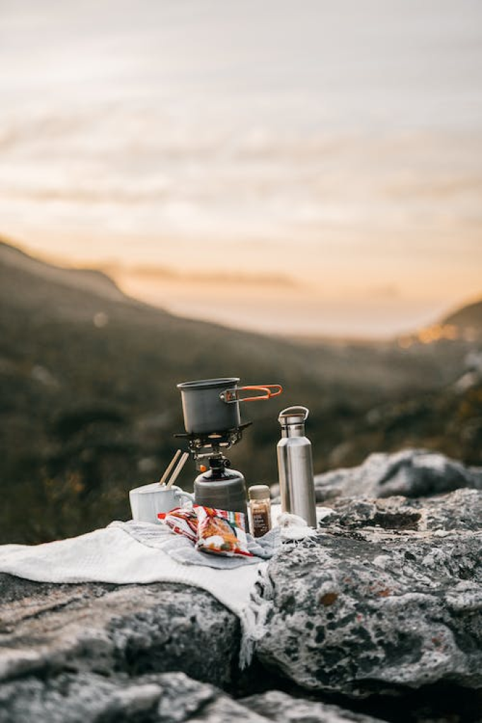 Iron cookware on a small camping stove in the mountains
