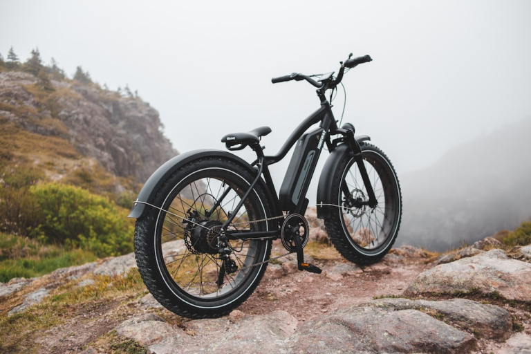 An electric mountain bike is parked on top of a rocky mountain this year.