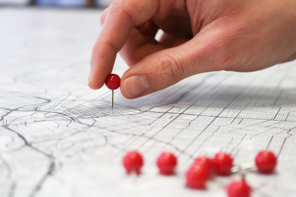  A person putting thumb pins on a detailed map.