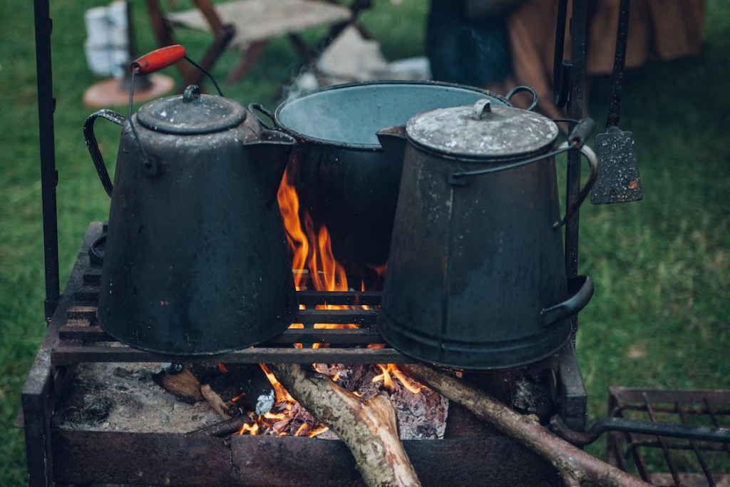 three grey pots on an outdoor campfire grill