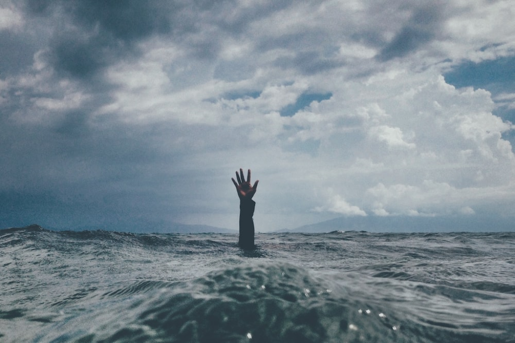 A person waving their hand from under the water.