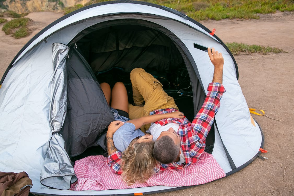 A couple taking a selfie inside a camping tent