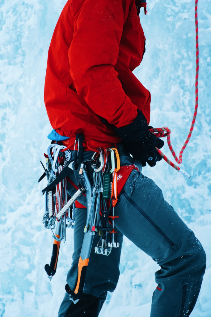 A climbing person with a belt full of climbing tools.