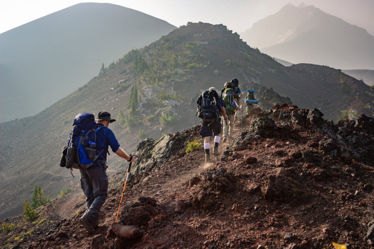 A group of hikers undergoing an essential gear checklist before hiking up a mountain.