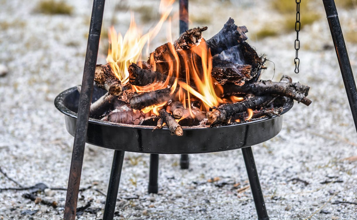 Burning logs on a grilling basket