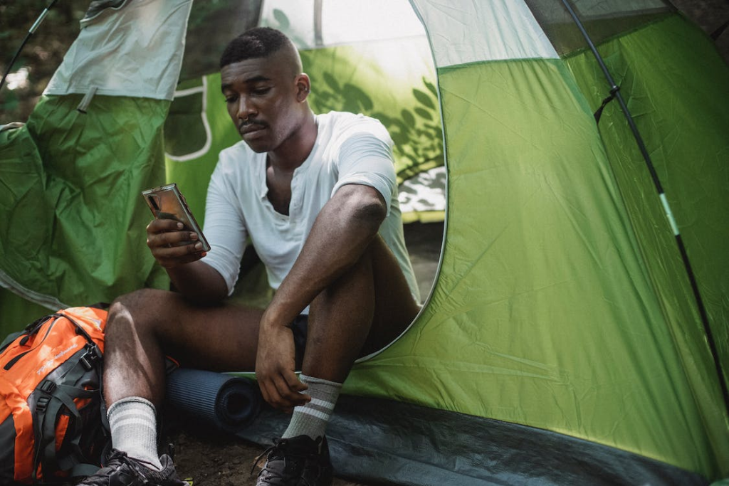 A camper using their cellphone in the tent